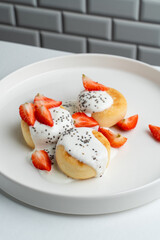 Cottage cheese fritters with strawberry and sour cream, white and light menu photography