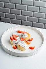 Cottage cheese fritters with strawberry and sour cream, white and light menu photography