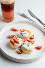 Close up high angle view photo for appetizing commercial of modern russian restaurant, small russian syrniki with berries and cream