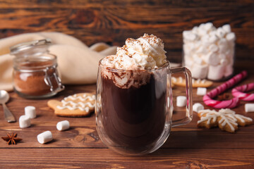 Glass cup of tasty hot chocolate on wooden background
