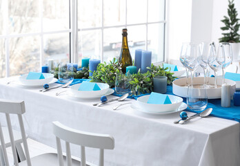 Dining table with beautiful setting for Christmas celebration and blank cards in room