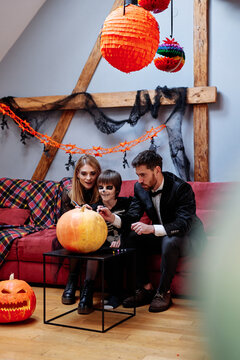 Family enjoying process of drawing pumpkin by markers