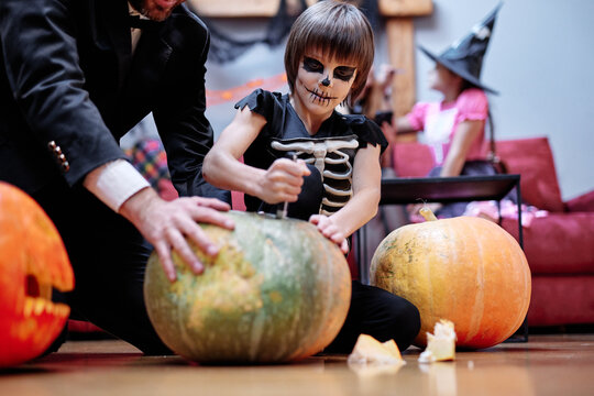 Boy Opening Top Of Pumpkin And Preparing For Carving