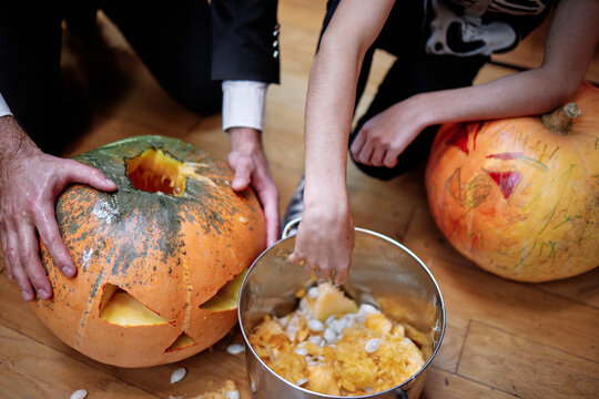 Two person emptying pumpkin of seeds