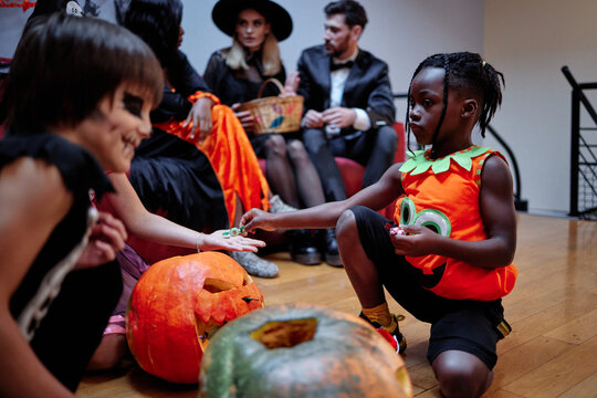 Boy giving away sweets schoolmates during Halloween
