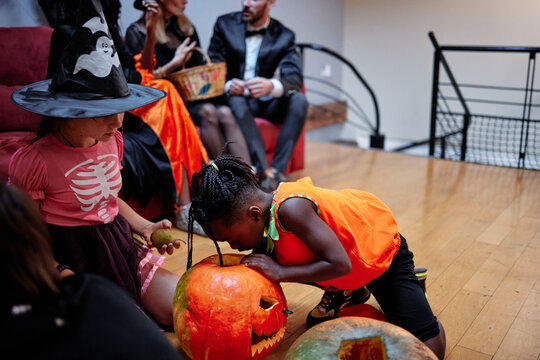 Children playing games with carved pumpkin 