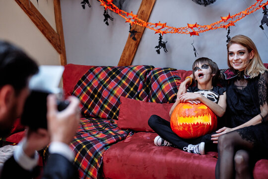 Boy and woman posing at camera during Halloween party