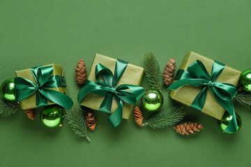 Christmas gifts, fir branches, cones and decorations on green background