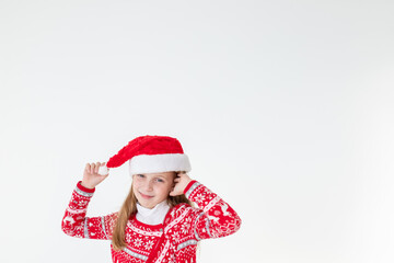 portrait of happy girl dancing ,wearing red christmas sweater and santa hat isolated on white background.young caucasian joyful smiling blonde girl in a Christmas red deer sweater is happy.