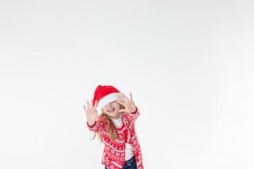 portrait of happy girl dancing ,wearing red christmas sweater and santa hat isolated on white background.young caucasian joyful smiling blonde girl in a Christmas red deer sweater is happy.