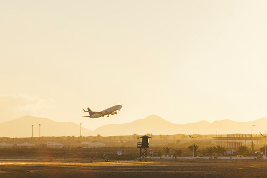 Airplane flying over runway in countryside