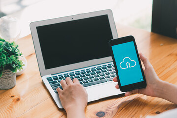 Cloud uploading concept on phone screen. Man hand hold phone doing cloud uploading.