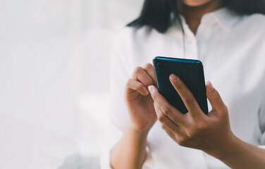 Close-up of woman holding a smartphone and using online social on lifestyle. Technology for communication concept, copy space.