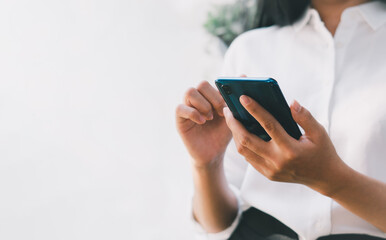 Close-up of woman holding a smartphone and using online social on lifestyle. Technology for communication concept, copy space.