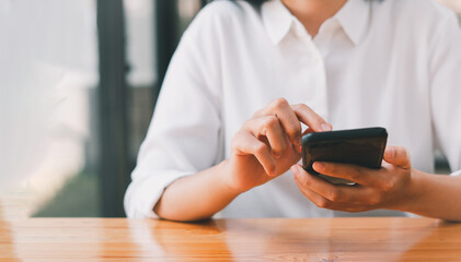 Close-up of woman holding a smartphone and using online social on lifestyle. Technology for communication concept, copy space.