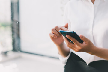 Close-up of woman holding a smartphone and using online social on lifestyle. Technology for communication concept, copy space.