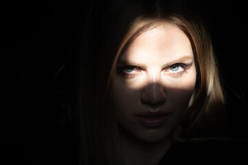 Woman in shadow. Female serious model with shadows on face looking seductive and sensual on...
