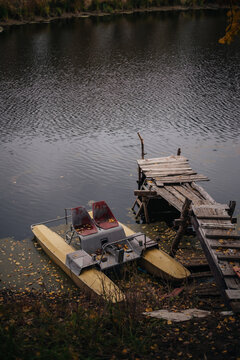 Old pedal boat by the wooden rural pier