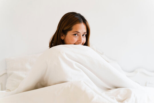 Smiling Female Covering Face With Blanket