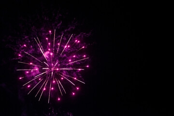 round fireworks and purple fireworks against the black sky. Christmas fireworks in the night sky. Christmas fireworks in the night sky