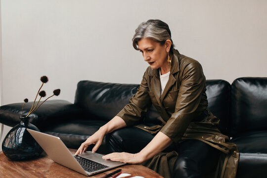 Stylish senior businesswoman working on laptop