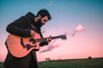Playing guitar intensely during sunset