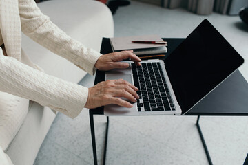 Mature woman working on laptop in modern office