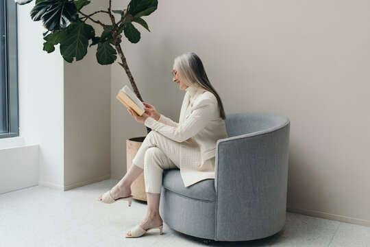 Happy woman reading a book in luxury interior