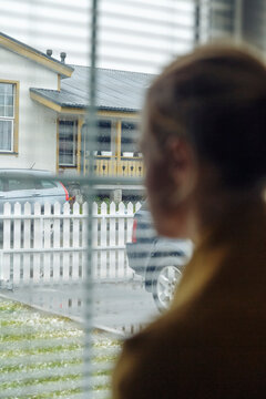 Woman looking at snowy suburban street