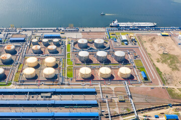 Aerial view of oil tankers moored at an oil storage silo terminal port and railway road infrastructure ground.