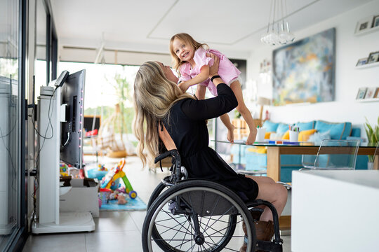 Mother in wheelchair playing with her daughter