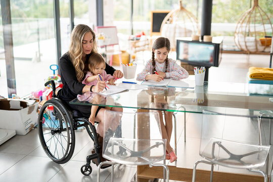 Mother doing homework with her daughters