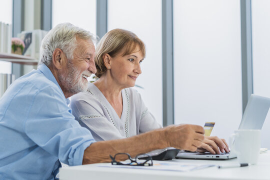 Happy Older Husband, Wife Senior Couple Elderly Family, Caucasian Mature, Adult And Retirement Using Laptop Computer With Credit Card, Shopping Online At Home, Pay For Purchase, Pay Surfing Internet.