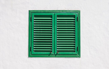 White wall with green wooden window