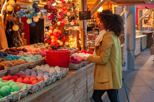 woman in christmas market buying garland, Europe