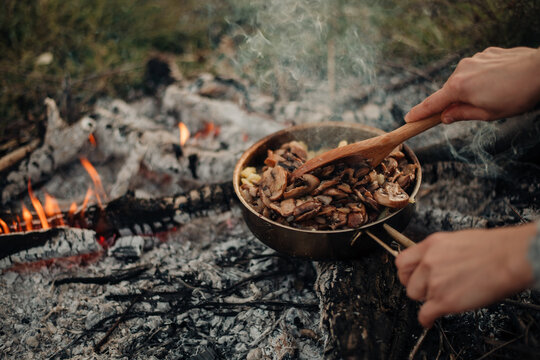cooking outdoors, frying mushrooms on the skillet pan