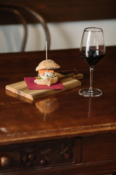 Still Life Of Red Wine And Finger Food On Wooden Table