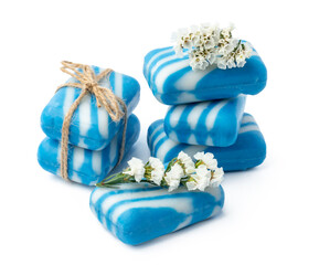 Bars of handmade natural soap and flowers on white background