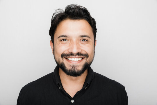 Smiling South Asian Man against a white background.