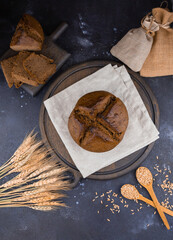 round bread on a wooden board, sliced ​​bread and wheat