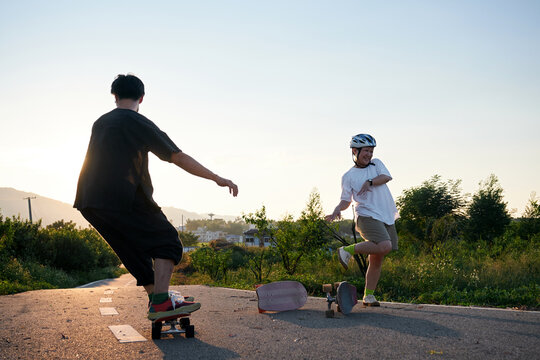 Asian friends playing skateboard