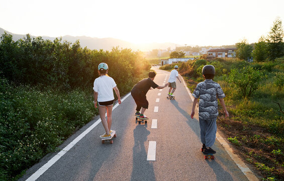 A group of Asian friends are skateboarding