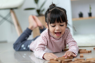 Asian sibling  girl playing wooden stacks at home