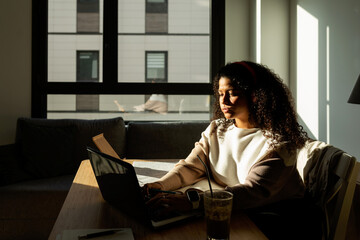 Pretty woman working in office at sunset