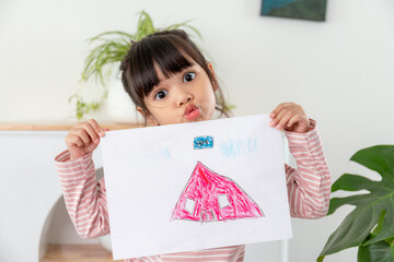Little preschool girl displaying her picture proudly