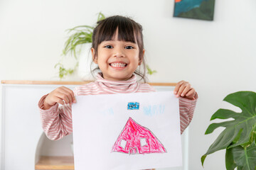 Little preschool girl displaying her picture proudly