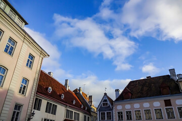 Fototapeta na wymiar Yellow building facade on Town Hall Square (Raekoja plats) on a sunny day with blue sky. Tallinn, Estonia, Europe. November 2021