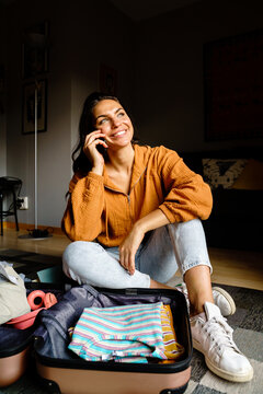 Woman packing suitcase and calling