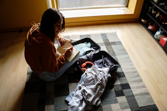 Woman checking travel suitcase