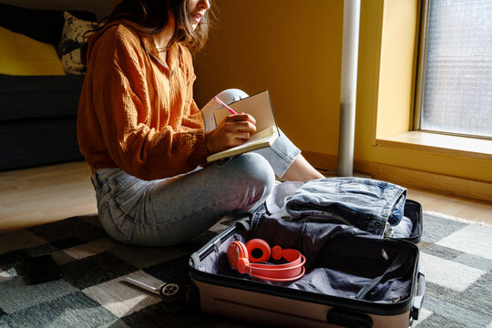 Woman preparing travel suitcase